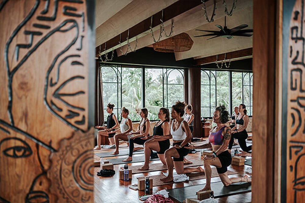 Group yoga class practicing lunges in studio