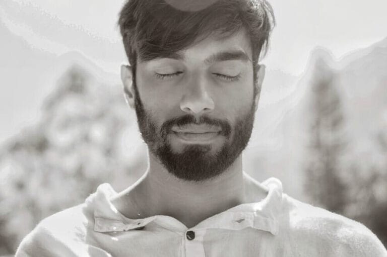 Bearded man meditating outdoors with eyes closed