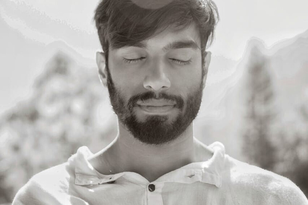 Bearded man meditating outdoors with eyes closed