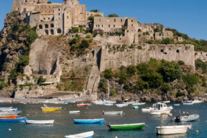 Cliffside stone fortress overlooking boats in harbor