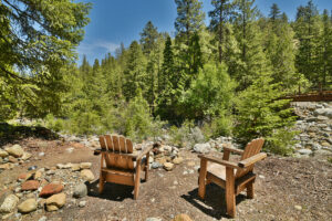 Two wooden chairs overlooking forest creek