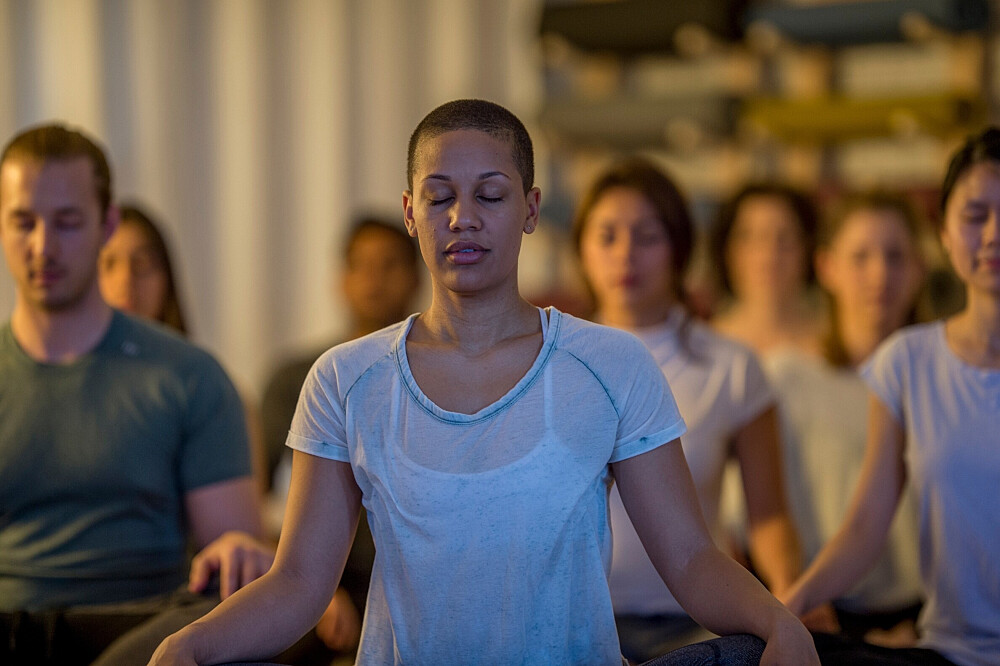 Group meditating in yoga class indoors