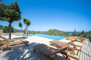 Infinity pool with ocean view and lounge chairs