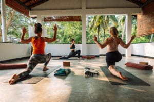 Three women practicing yoga in open-air studio