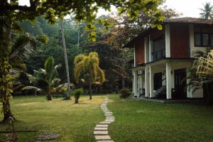 Tropical house with lush garden and stone path