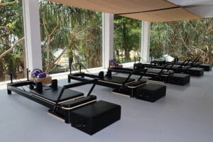 Bright Pilates studio with reformer machines and large windows