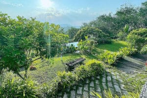 Lush garden with bench overlooking pond and hills
