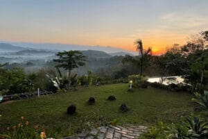Sunset over misty hills and tropical garden