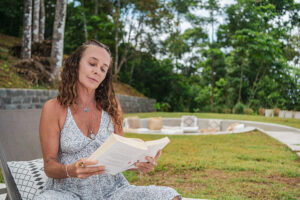 Woman reading book outdoors in garden setting