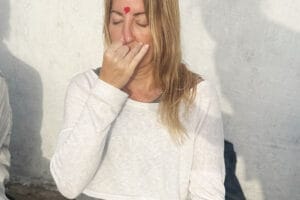 Woman practicing breathing exercise with heart on forehead