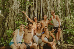 Group of friends posing by large jungle tree