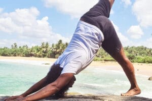 Person practicing yoga on a sunny beach