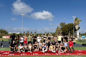 Group of athletes posing outdoors on workout field
