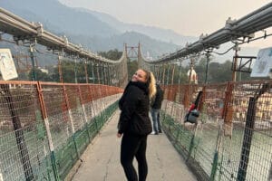 Woman smiling on suspension bridge over river