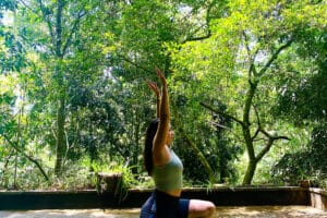 Woman practicing yoga in lush forest setting