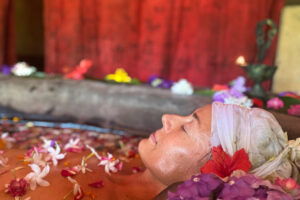 Woman relaxing in flower-filled spa bath