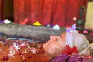 Woman relaxing in flower-filled spa bath