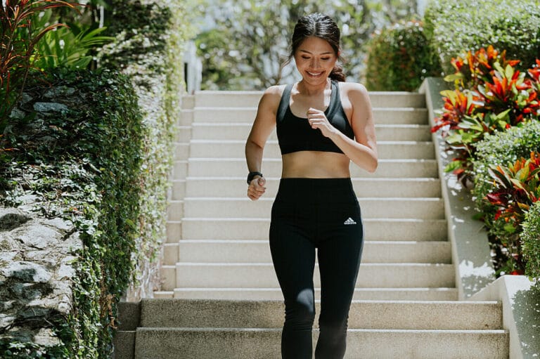Woman jogging down outdoor stairs in athletic wear