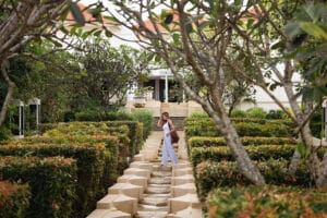 Woman walking up garden steps toward villa