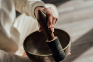 Hand striking a Tibetan singing bowl