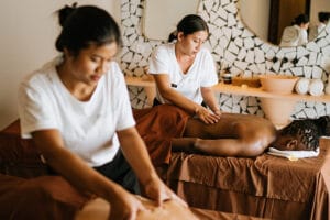 Two therapists giving massages in spa room