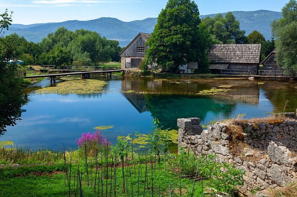 Rustic wooden houses beside clear mountain pond