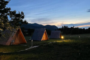 A-frame cabins at dusk in mountain meadow