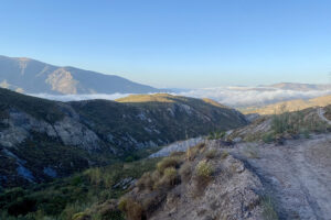 Mountain valley with low clouds and dirt road