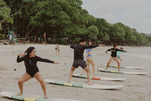Group practicing surf lessons on sandy beach