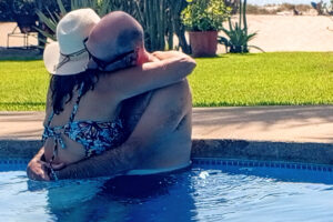Couple hugging in a sunny outdoor pool
