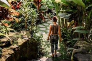 Woman walking through lush tropical garden path