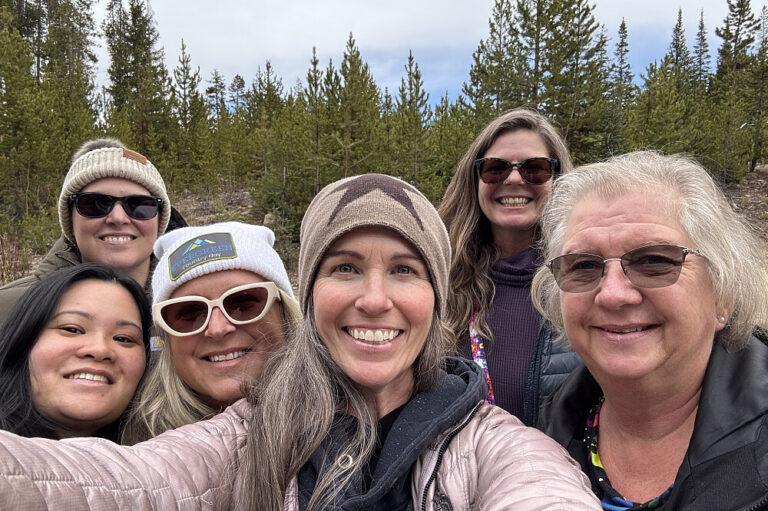 Six women taking selfie in forest setting