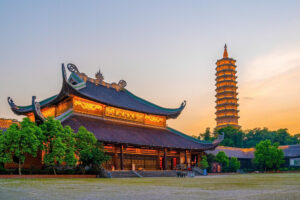Traditional Chinese temple and illuminated pagoda at sunset