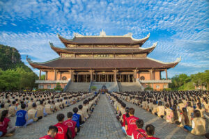 Large temple with crowd seated in courtyard