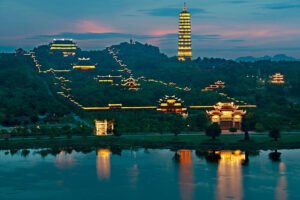 Illuminated Chinese temple complex and pagoda at dusk