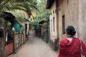 Woman walking down narrow village alleyway