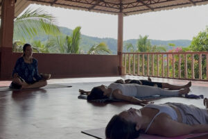 Yoga class relaxing in open-air tropical pavilion