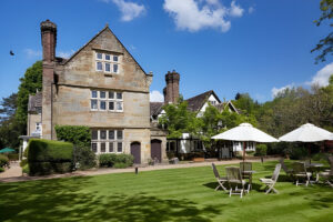 Historic stone manor with garden seating and umbrellas