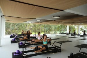 Women practicing Pilates on reformers in studio