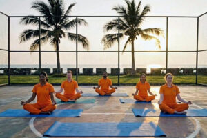 Group meditating on outdoor court at sunset