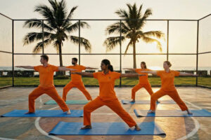 Group practicing yoga at sunset outdoors