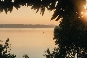 Small boat on calm lake at sunset