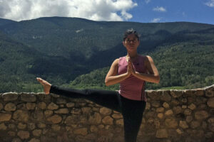 Person practicing yoga with mountain view backdrop