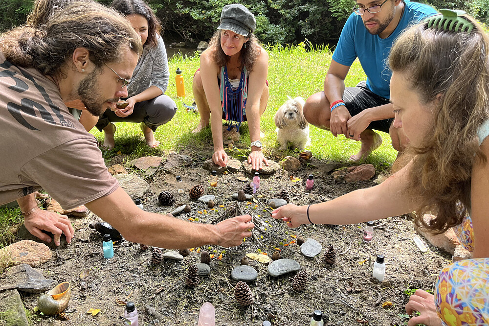 Group creating nature mandala outdoors with stones