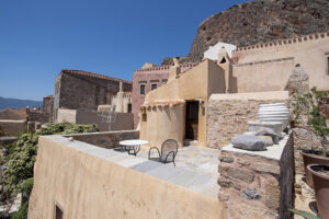Stone terrace house with mountain backdrop