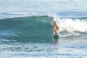 Surfer riding a turquoise ocean wave