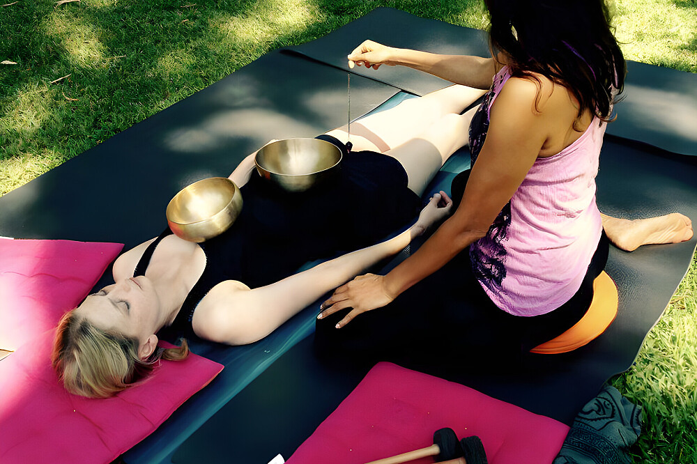 Woman receiving outdoor sound bowl therapy session