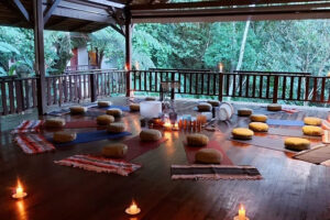 Open-air yoga pavilion with candles and cushions