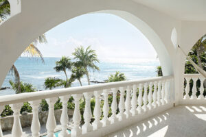 White arched balcony overlooking tropical ocean view