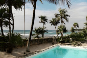 Tropical beachfront pool with palm trees and ocean